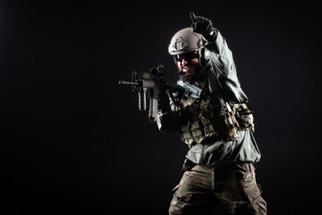 Fototapeta na wymiar American special forces, a soldier in a military uniform with a weapon attacks on a black background, a ranger for special operations