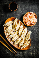 Dumplings of gyoza on a wooden plate with chopsticks. 