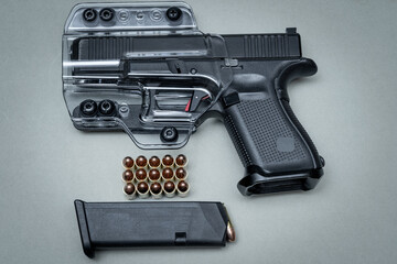 Compact pistol, cartridges and transparent holster.