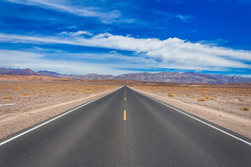 Fototapeta na wymiar Endless straight highway crossing the Mojave desert