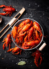 Boiled crayfish in a colander on a stone board. 
