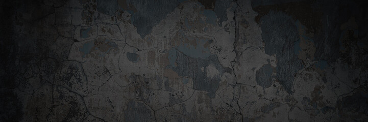 Texture of the old wall. Rough grungy surface of painted plastered concrete wall with spots, cracks, noise and grain. Dark wide panoramic background for design. Shaded vintage texture with vignette.