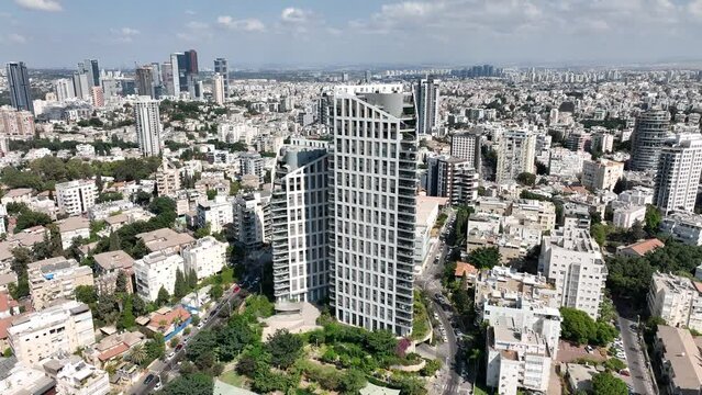 Aerial footage of a specially designed tower and houses in the city of Givatayim in Israel. In the background the skyline of Ramat Gan and Tel Aviv