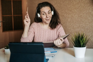 Young woman teacher conducts a lesson online. Online training. The teacher conducts the lesson over...
