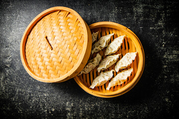 Fragrant gyoza dumplings in a bamboo steamer. 