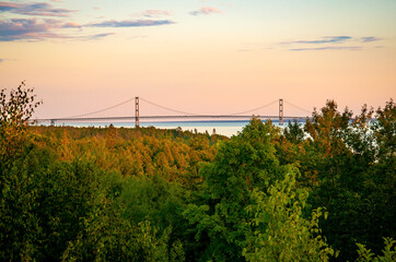 Mackinac Bridge at sunset dusk over Fall Color Trees Lake Michigan Shoreline