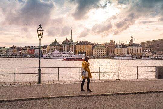 Lady walking by lake maklaren with Gamla stan on the background