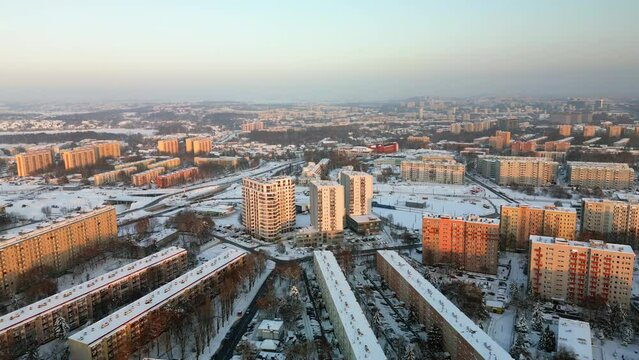 Aerial view of dormitory district at sunset in Krakow, buildings, streets and yards are covered with snow during winter. 