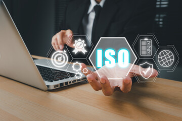 ISO standards quality control concept, Person hand holding iso icon on virtual screen on desk workplace, Assurance warranty, Business technology concept.
