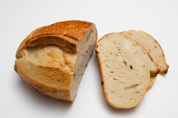 partially sliced loaf of the wheat sourdough hearth bread with bran on a white background