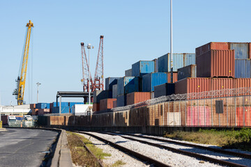 Obraz premium Many colorful cargo containers in the seaport behind the fence with barbed wire