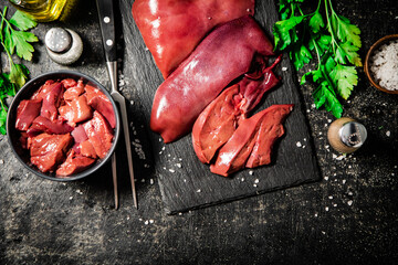 Raw liver on a stone board with parsley. 