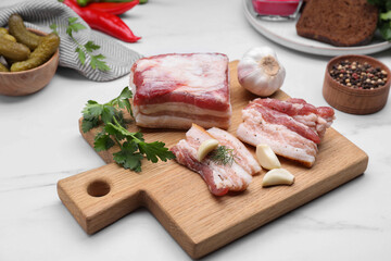 Tasty pork fatback with garlic and herbs on white marble table