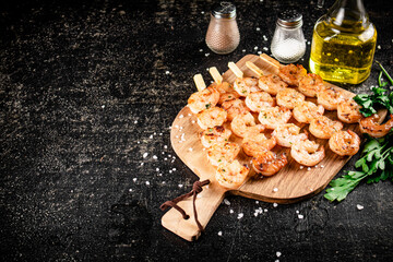 Grilled shrimp on a wooden cutting board. 