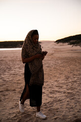 African woman with headscarf using cell phone