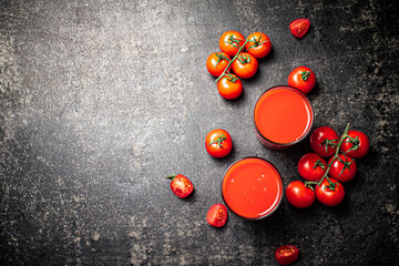 Fresh tomato juice. On a black background.