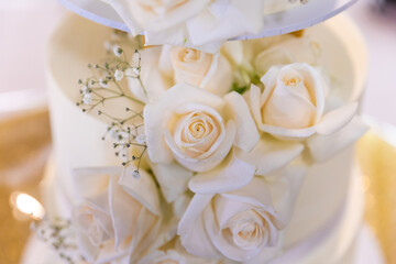 Obraz na płótnie Canvas Beautiful white wedding cake decorated with roses close up