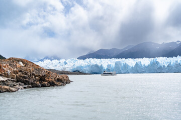Un barco está navegando en frente del glaciar Perito Moreno en el Calafate Argentina.