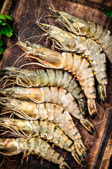 Fresh raw shrimp on a wooden cutting board.