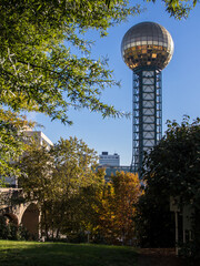 The Sunsphere tower in Knoxville, Tennessee, framed by tree against blue sky. - obrazy, fototapety, plakaty
