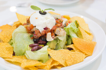 Mexican Nachos in white plate on dining table in mexican restaurant