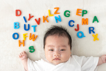 Fototapeta na wymiar 起きている赤ちゃんと玩具のアルファベット（0歳1か月、日本人、男の子）