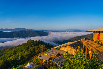 Old bamboo hut with sea of fog on mountains in morning
