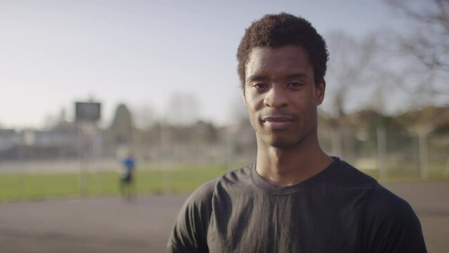 Portrait of young basketball player looking to camera with a blank expression, in slow motion