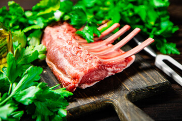 Raw rack of lamb on a parsley cutting board. 