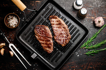 Aromatic grilled steak in a frying pan. 