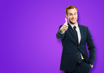 Image of excited businessman showing thumbs up like hand sign gesture, in black suit, on violet...