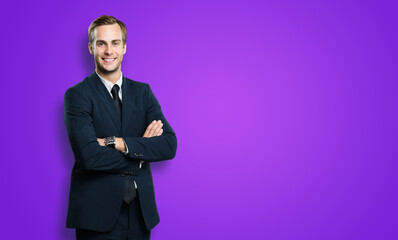 Obraz na płótnie Canvas Portrait of businessman in black confident suit, with crossed arms, on violet purple background. Business concept. Smiling man at studio picture. Copy space for text.