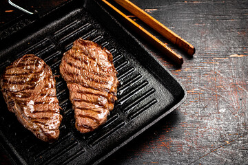 Aromatic grilled steak in a frying pan. 
