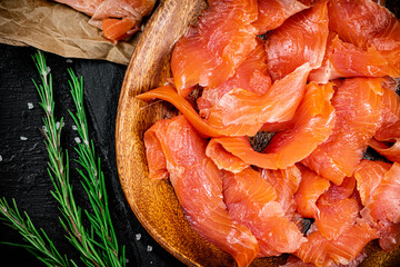 Salted salmon on a wooden plate with greens. 