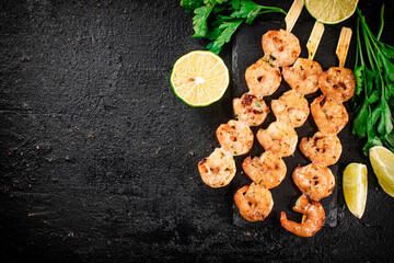 Grilled shrimp on a stone board with parsley and lime.
