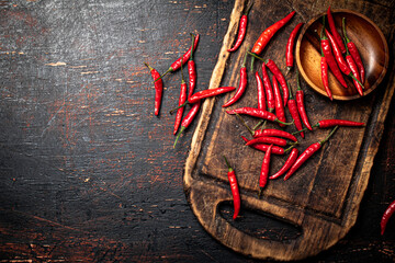 Red chili pepper pods on a cutting board.