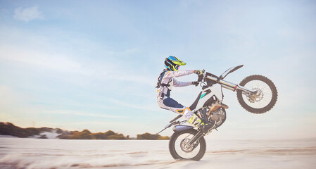 Obraz premium Motorbike, motorcycle athlete and desert drive with mockup cycling in nature for sport adventure. Jump, freedom and sports driving training of a man with speed on sand trail for fitness and exercise