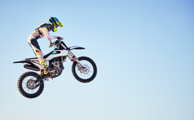 Fototapeta na wymiar Motorcycle, jump and person on blue sky mockup for training, competition or challenge with safety gear. Professional cycling, motorbike and adventure with speed, sports and danger in mock up space