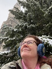 woman standing in front of a snow covered spruce tree