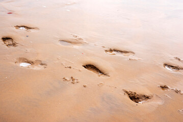 Close-up of footprints on empty beach sand