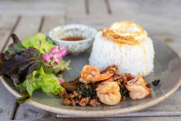 Spicy fried pork and shrimp with basil leaves, stir fried basil, the famous traditional Thai food served with jasmine rice and fried egg.