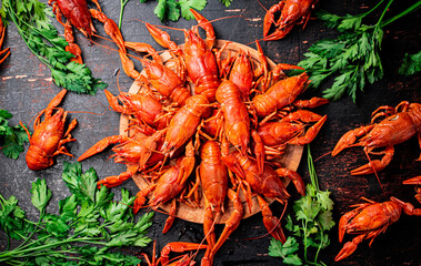 Boiled crayfish on a wooden cutting board with parsley. 