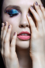 Beautiful brunette with blue eye shadow make up and rhinestones. Eyes closed.
