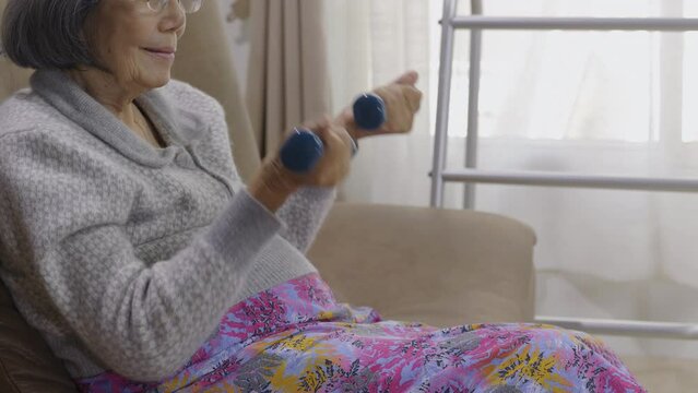 Elderly woman is exercise on sofa at nursing home.