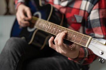 Practicing in playing guitar. Close up of male hands playing guitar.