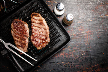 Aromatic grilled steak in a frying pan. 