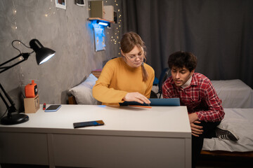 College students sitting at desk in dormitory when having prepare for exam.