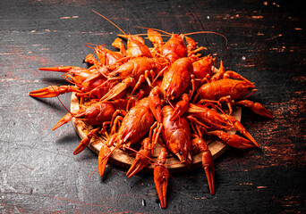 Boiled crayfish on a round cutting board. 