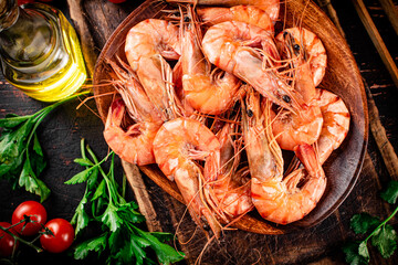 Boiled shrimp on a plate with tomatoes and parsley. 