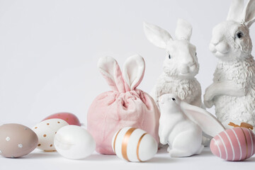 A beautiful postcard. Banner. The concept of a bright Easter holiday. White rabbits and Easter eggs on a white isolated background.